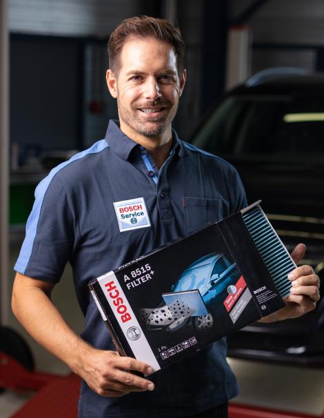  Un mécanicien Bosch Car Service avec un filtre Bosch+ dans ses mains
